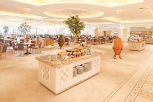 a restaurant with tables and chairs in a room at Mövenpick Resort & Marine Spa Sousse in Sousse
