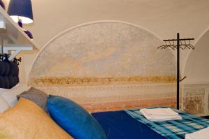 ein Schlafzimmer mit einem Bett mit einem Kreuz an der Wand in der Unterkunft Antico Monastero Di Anacapri in Anacapri