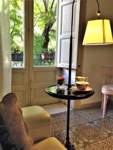 a room with a table and a lamp and a window at A Casa di Amelie in Palermo