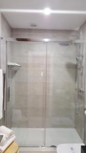 a bathroom with a shower stall and a glass door at Art Suite in Santander