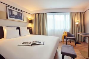 ein Hotelzimmer mit einem Bett mit einem Buch darauf in der Unterkunft Mercure Paris Saint-Ouen in Saint-Ouen