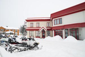 un groupe de motocycles garés dans la neige devant un bâtiment dans l'établissement Auberge l'Ambassadeur, à Amqui