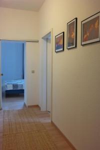 einen Flur mit drei Bildern an der Wand und ein Schlafzimmer in der Unterkunft Ferienwohnung Wartburgblick in Eisenach
