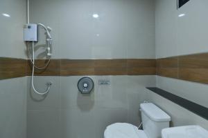 a bathroom with a toilet and a shower stall at Jarat Mansion in Surin