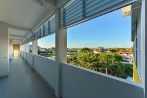 a hallway with large windows in a building with a view of a city at Jarat Mansion in Surin