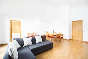 a living room with a couch and a table at Font del Ferro Apartments in El Tarter