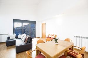 a living room with a table and a couch at Font del Ferro Apartments in El Tarter