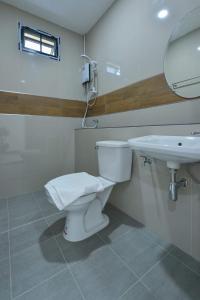 a bathroom with a toilet and a sink at Jarat Mansion in Surin