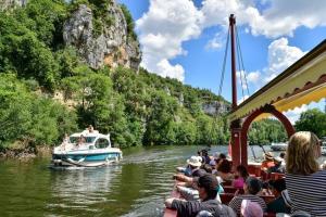 un grupo de personas montando en un barco en un río en allees des soupirs, en Cahors