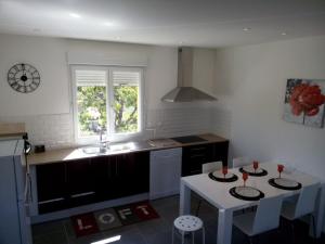 a kitchen with a table and a sink and a table and chairs at GITE DE L'OISILLIERE in Huisseau-sur-Cosson