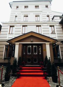 a white building with a red carpet in front of it at Central Magnat Cinema in Chernivtsi