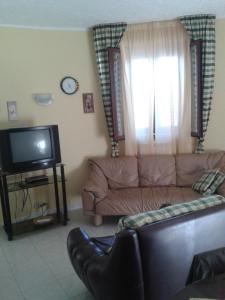 a living room with a couch and a tv at Villa La Martina in Fontane Bianche