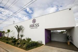 a large white building with a purple garage at Hauss Excellence Motel in Sete Lagoas