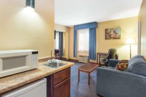 a hotel room with a kitchen and a living room at Baymont by Wyndham Waukesha in Waukesha