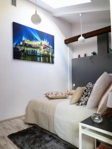 a bedroom with a bed with a painting on the wall at Apartament krakowski GIMO na Kazimierzu in Krakow