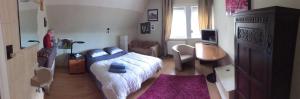 a bedroom with a bed and a desk and a chair at Villa DM in De Haan