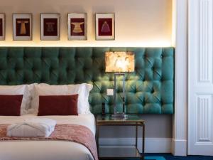 een slaapkamer met een bed met een groen hoofdeinde bij Dear Lisbon - Bordalo Palace Chiado in Lissabon