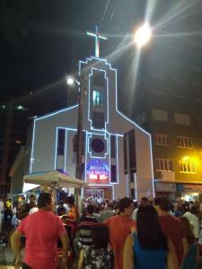 a crowd of people standing in front of a church at night at Apto Ocian in Praia Grande