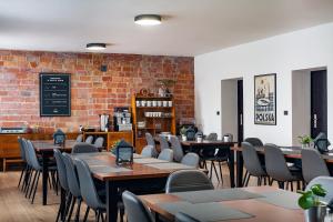a restaurant with tables and chairs and a brick wall at Avion Hotel in Świdnik