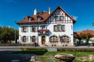 ein großes weißes Haus mit braunem Dach in der Unterkunft Gasthof Drei Eidgenossen in Bösingen