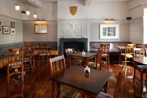 Un restaurante con mesas y sillas y chimenea. en The Royal Oak, en Settle
