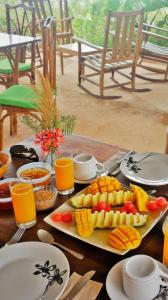 a table topped with plates of food and orange juice at Tierra Madre Eco Lodge in Los Andes