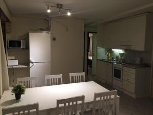 a kitchen with a table and chairs and a refrigerator at Mänty Holiday Apartments in Rovaniemi