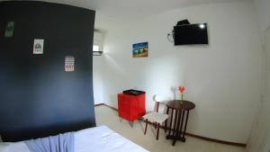 a bedroom with a bed and a tv on the wall at Suites Vida Mansa in Maresias