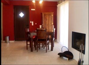 a dining room with a table and chairs and red walls at Naiades Village in Polydrossos