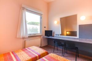una camera d'albergo con scrivania e specchio di AutoHotel a Formello