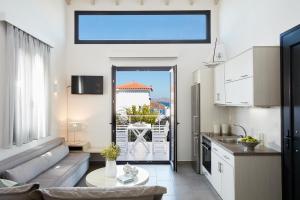 una cucina e un soggiorno con divano e tavolo di Eleia Seafront Rooms & Villas a Pétra