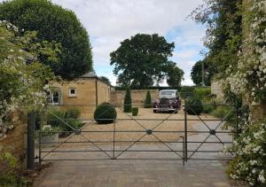 an open gate with a car parked in a driveway at Pea Cottage in Stamford