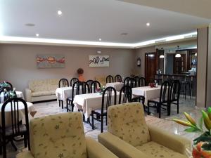 a dining room with white tables and chairs and a woman at Hotel Castro in Santiago de Compostela