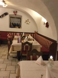 a dining room with tables and chairs and an archway at Garni Val Udai in Mazzin