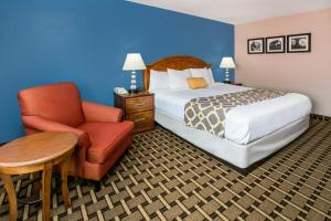 a hotel room with a bed and a chair at Quality Inn Lawton near Fort Sill in Lawton +10 photos