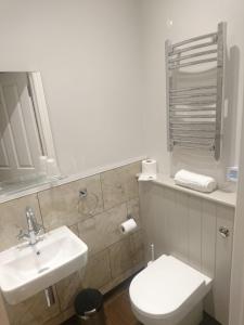 a white bathroom with a sink and a toilet at The Milford Arms in Hounslow