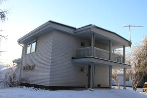 a house with a balcony in the snow at Mänty Holiday Apartments in Rovaniemi