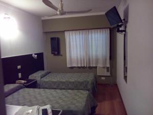 a hotel room with two beds and a window at Petit Hotel in Chivilcoy
