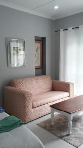 Johannesburg的住宿－@Home Cottage，带沙发和咖啡桌的客厅