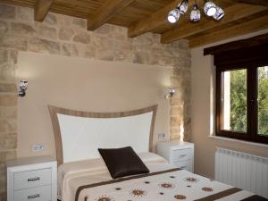 a bedroom with a bed with a headboard and a window at Apartamentos La Fabrica in Villaluenga de la Vega +52 photos