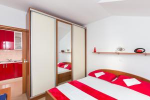 a bedroom with a red and white bed and a bathroom at Apartment Marko Dubrovnik in Dubrovnik