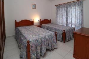 a hotel room with two beds and a window at Villa Estela in Albufeira