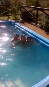 un grupo de tres personas en una piscina en Posada De Mar Siguiendo La Luna en La Lucila del Mar