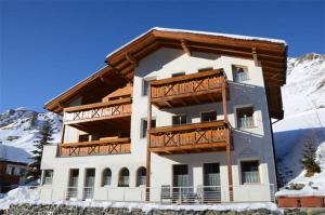 un gran edificio con balcones de madera en la nieve en Apart Montanara, en Samnaun 6 fotos más