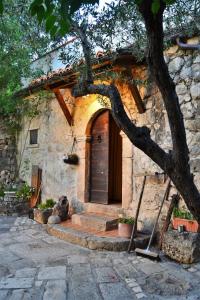 a stone house with a tree in front of it at Fattoria La Tana della Volpe in Pacentro