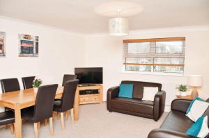 un soggiorno con tavolo, sedie e TV di Blackwater Meadow Apartment a Ellesmere