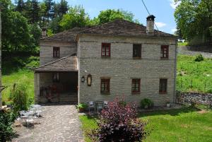 ein altes Backsteinhaus mit einer Terrasse im Hof in der Unterkunft Hotel Kaiti in Papigko