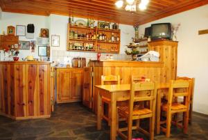 a kitchen with wooden cabinets and a table and chairs at Hotel Kaiti in Papingo