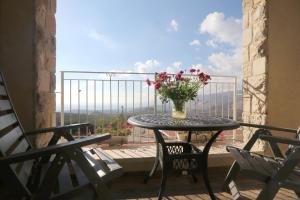 a table with a vase of flowers on a balcony at HaBaronit in Metulla