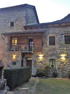 Cette grande maison en pierre possède un balcon. dans l'établissement Casa Coll, à Barruera